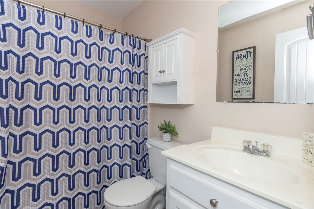 861 North Old Pendleton Road Liberty, SC 29657 - Photo 25 of 45 A well-lit bathroom features a vanity, toilet, and a patterned shower curtain.