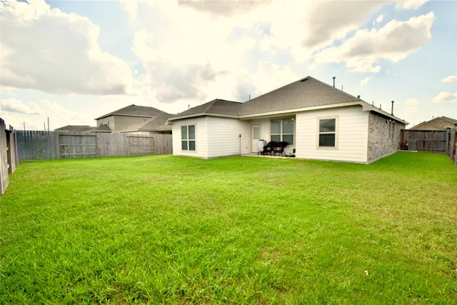 a view of a house with a yard and sitting area