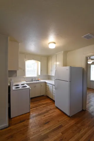 a kitchen with a cabinets and wooden floor