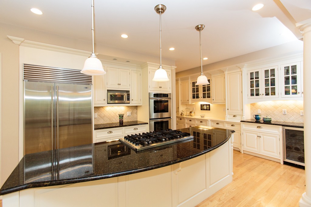 24 Sabrina Road Wellesley, MA 02482 - Photo 8 of 21 a large kitchen with granite countertop a stove refrigerator a sink a oven and a dining table with wooden floor