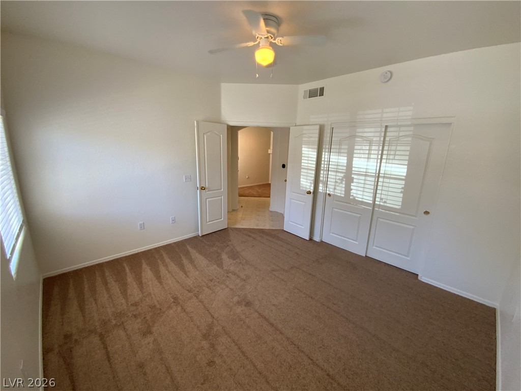 7400 West Flamingo Road, Unit 1039 Las Vegas, NV 89147 - Photo 16 of 40 A well-lit bedroom features plush carpeting and a convenient closet, offering comfort and practical storage.