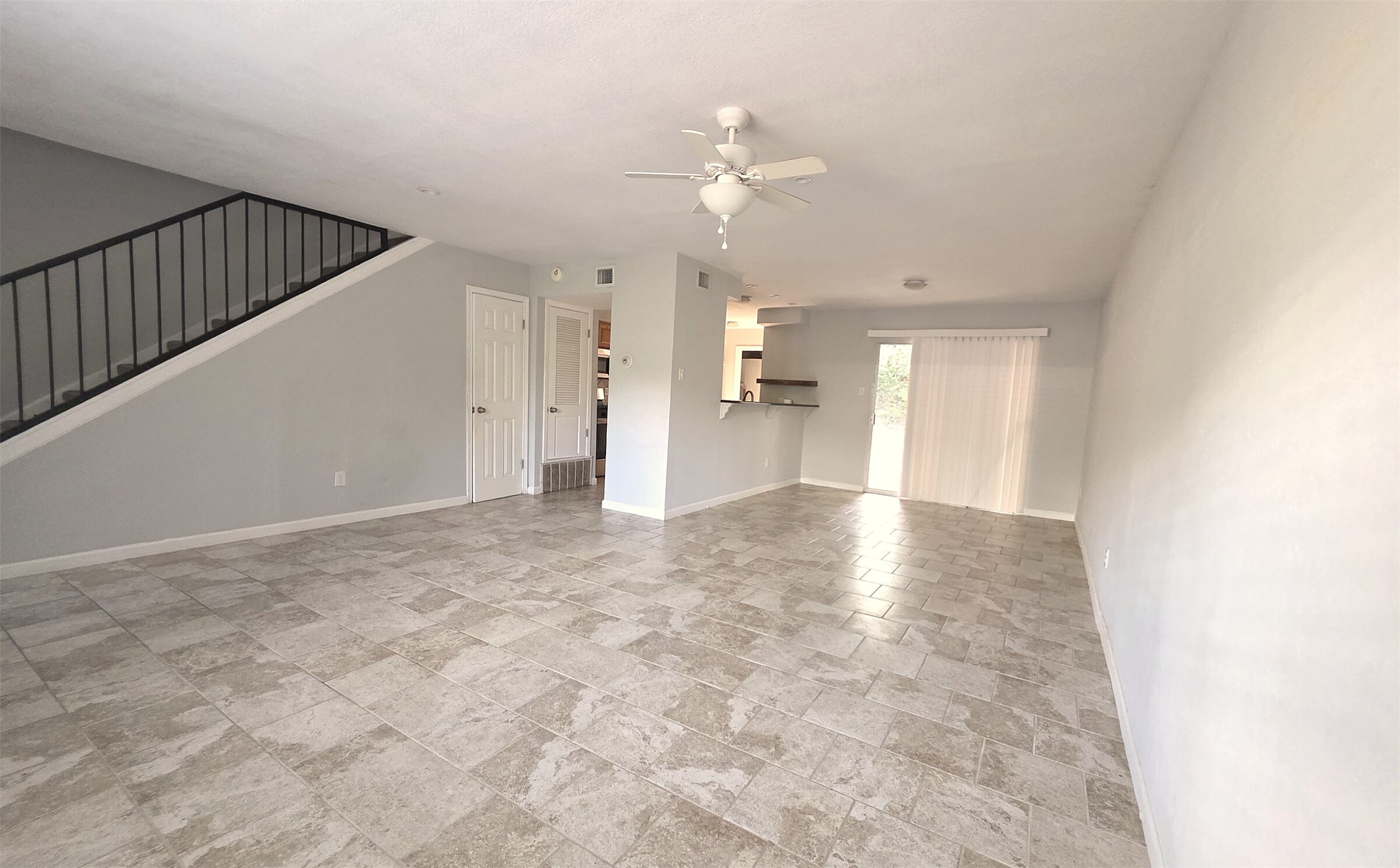703 Castle Ridge Road, Unit B Austin, TX 78746 - Photo 2 of 18 Stone-look tile floors and a classic staircase define this versatile open living space.