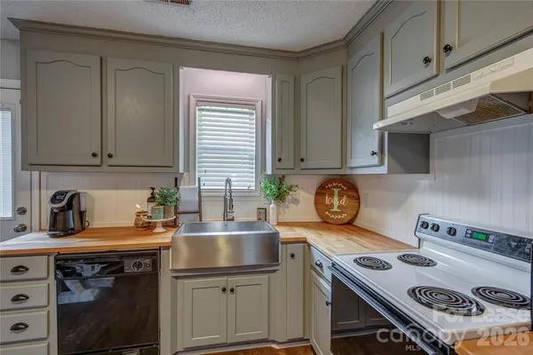 a kitchen with stainless steel appliances granite countertop a sink a stove and cabinets