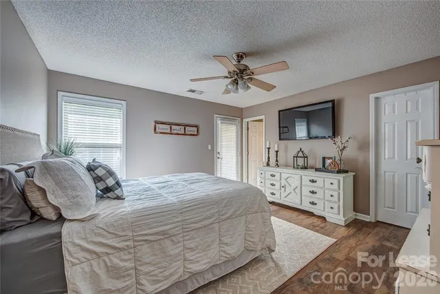 a bedroom with a large bed and a flat tv screen on dresser