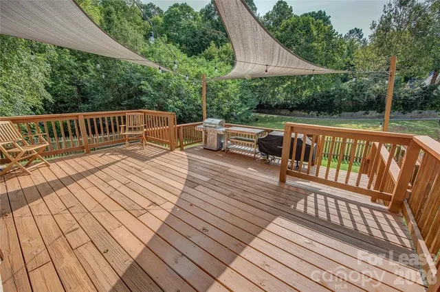 a balcony with wooden floor outdoor seating and yard in the back