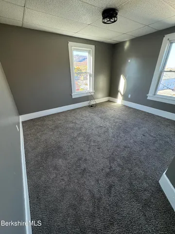 an empty room with windows and closet