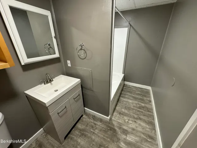 a bathroom with a sink and mirror with toilet
