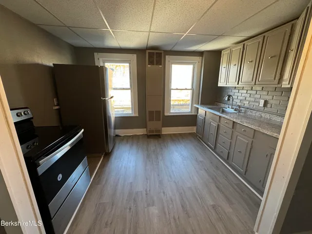 a view of kitchen with wooden floor and electronic appliances