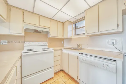 a kitchen with stainless steel appliances granite countertop a sink a stove and white cabinets