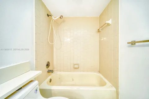a white bath tub sitting next to a shower