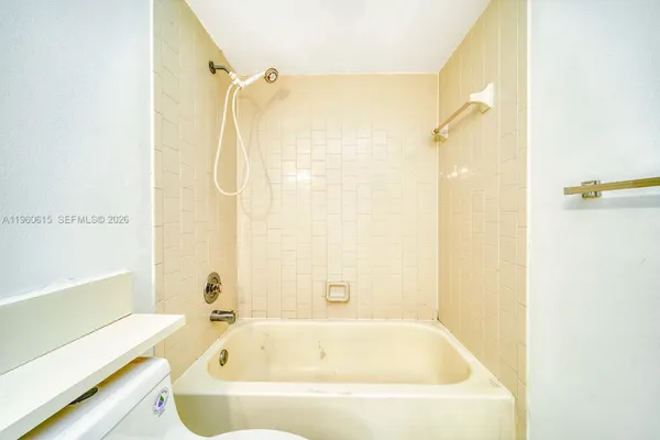 a white bath tub sitting next to a shower