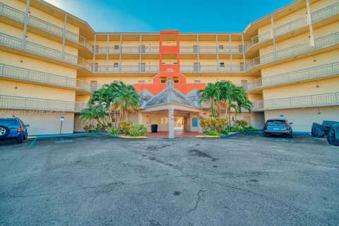 a view of a blue house with a yard and table and chairs