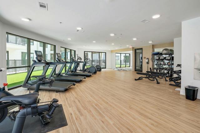 1701 Simond Avenue, Unit 615 Austin, TX 78723 - Photo 16 of 25 Spacious fitness center featuring wood-finish flooring, recessed lighting, and expansive windows