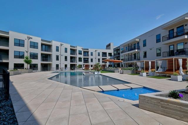 1701 Simond Avenue, Unit 615 Austin, TX 78723 - Photo 23 of 25 Outdoor aquatic area featuring a large, irregularly shaped swimming pool with integrated spa and a rectangular water feature
