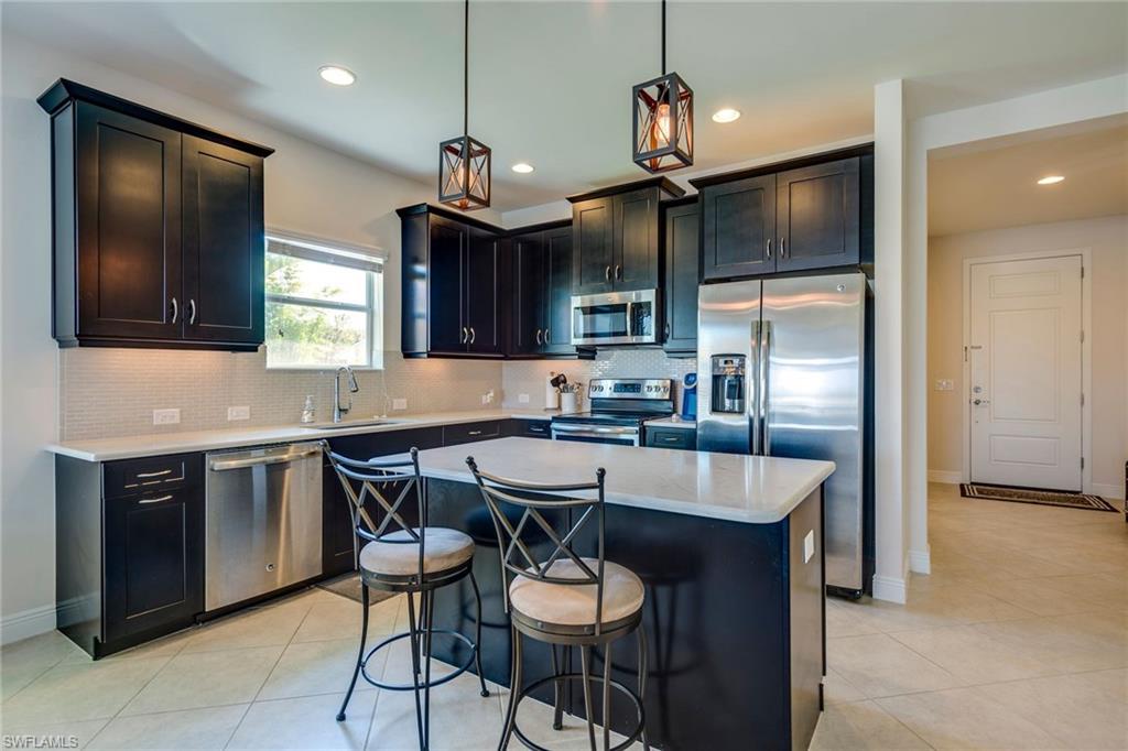 3782 Canopy Circle Naples, FL 34120 - Photo 15 of 31 a kitchen with stainless steel appliances granite countertop a sink a stove a refrigerator and island