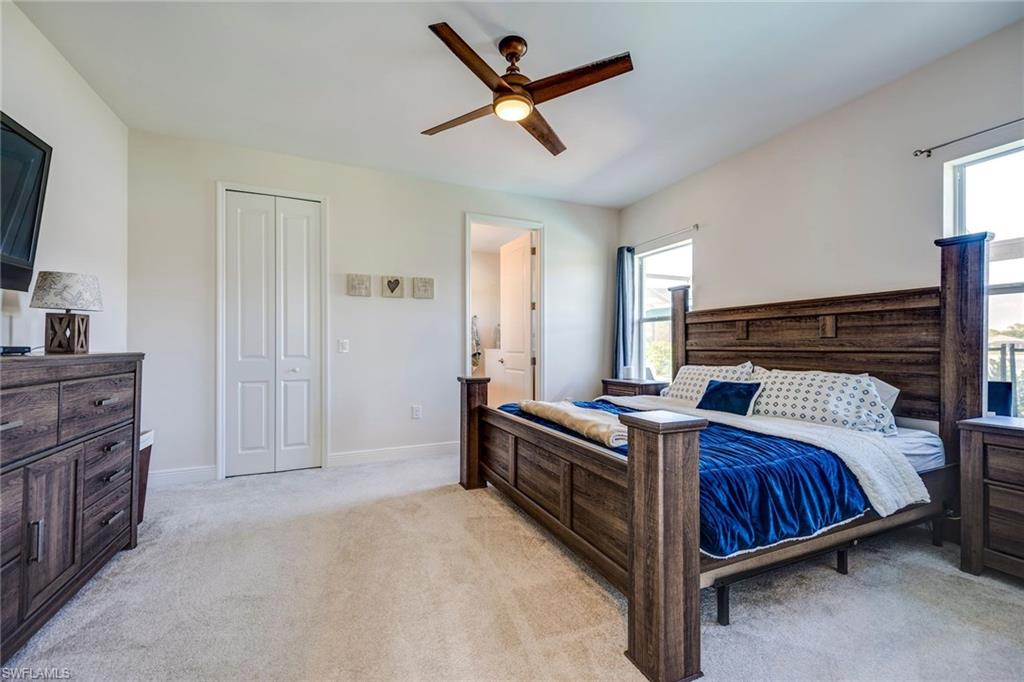 3782 Canopy Circle Naples, FL 34120 - Photo 19 of 31 a bedroom with a bed and a chandelier