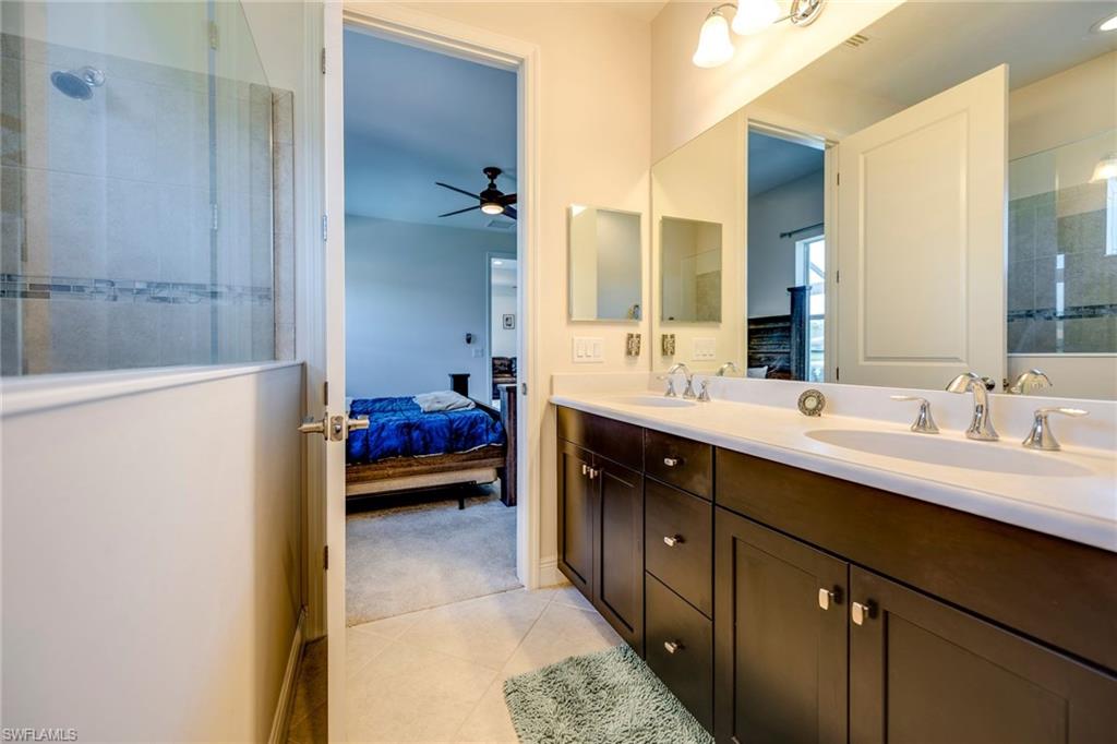 3782 Canopy Circle Naples, FL 34120 - Photo 22 of 31 a en suite bathroom with a double vanity sink a mirror and a bathtub