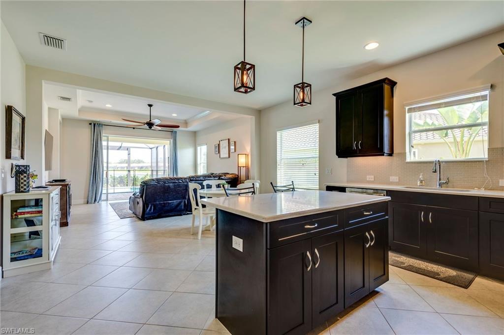 3782 Canopy Circle Naples, FL 34120 - Photo 4 of 31 a kitchen with a sink a counter top space appliances and cabinets