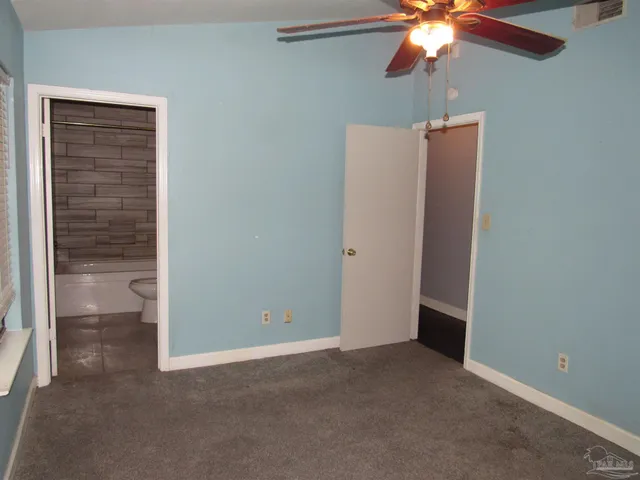 an empty room with a chandelier fan