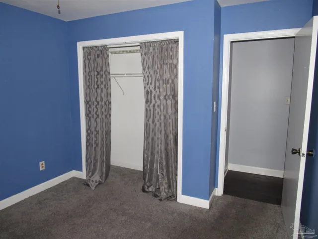 a view of an empty room with closet