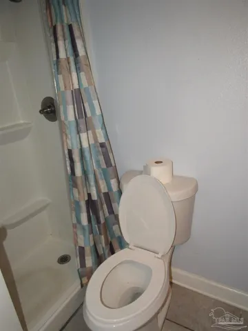 a white toilet sitting next to a shower