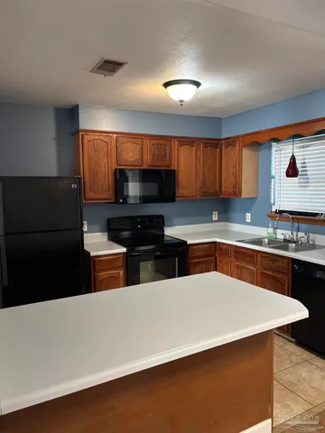 a kitchen with stainless steel appliances a stove a sink a microwave a refrigerator and cabinets