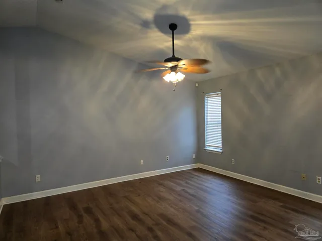 a view of empty room with wooden floor chandelier