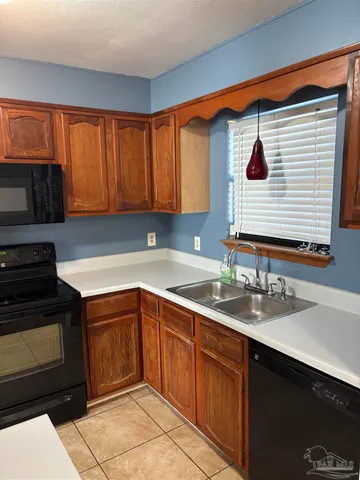 a kitchen with a sink cabinets and a window