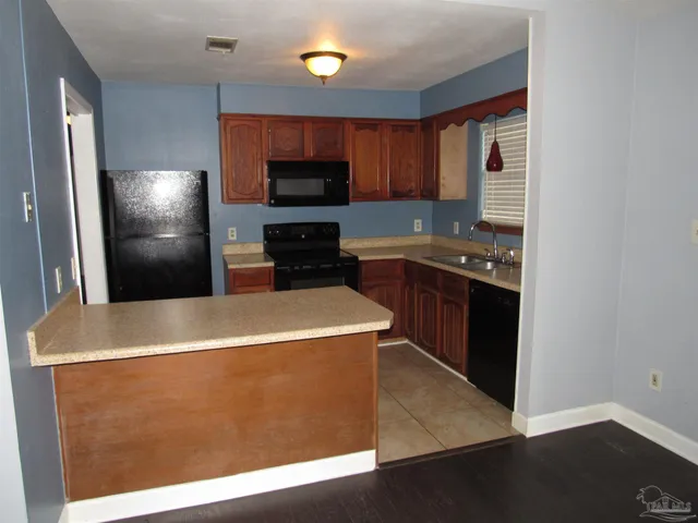 a kitchen with stainless steel appliances granite countertop a refrigerator a stove a sink and a microwave