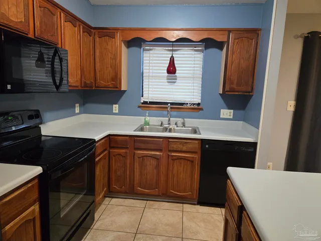 a kitchen with granite countertop cabinets sink and stainless steel appliances
