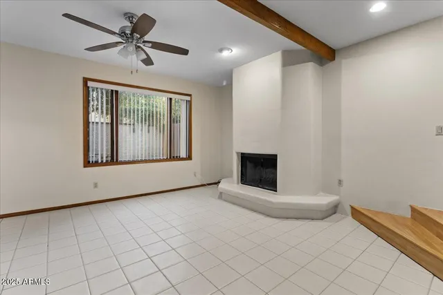 a view of an empty room with a fireplace and a window