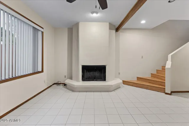 a view of an empty room with a fireplace and a window