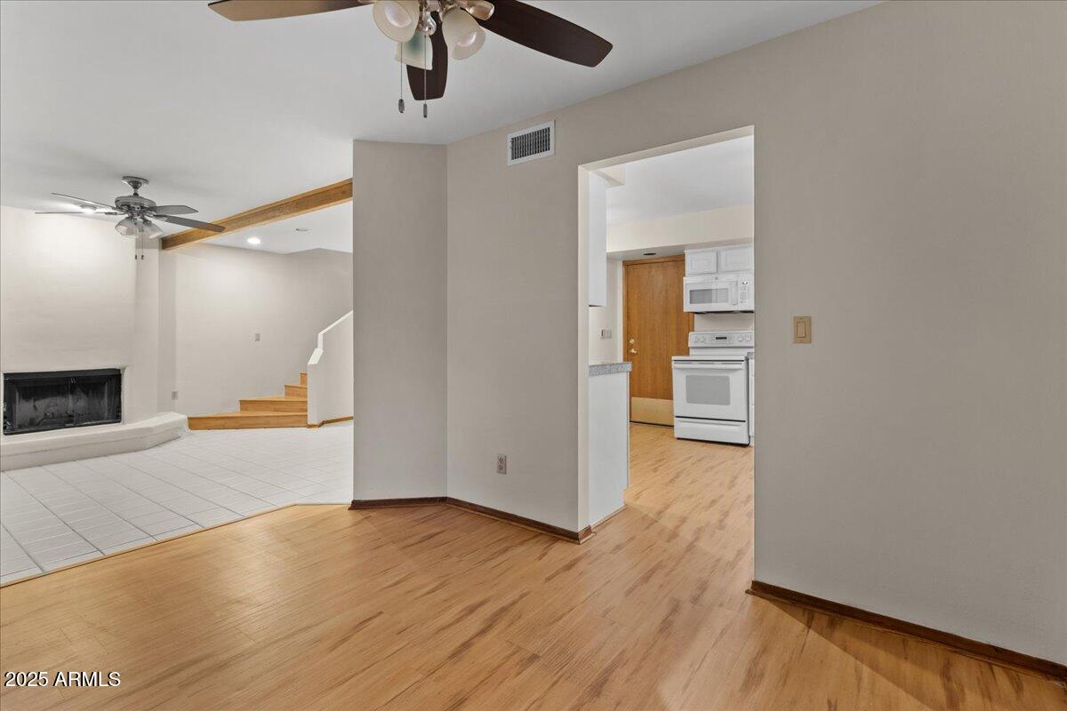 5750 North 10th Street, Unit 5 Phoenix, AZ 85014 - Photo 17 of 37 an empty room with wooden floor a ceiling fan and windows