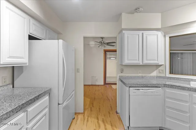 a kitchen with white cabinets and refrigerator