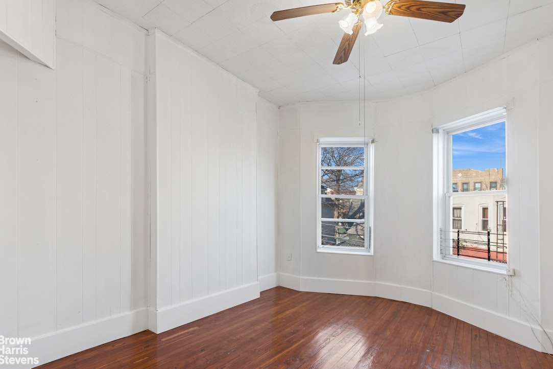 251 Rutland Road Brooklyn, NY 11225 - Photo 8 of 16 a view of an empty room with window and wooden floor
