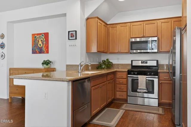 a kitchen with stainless steel appliances granite countertop a stove a sink and a microwave