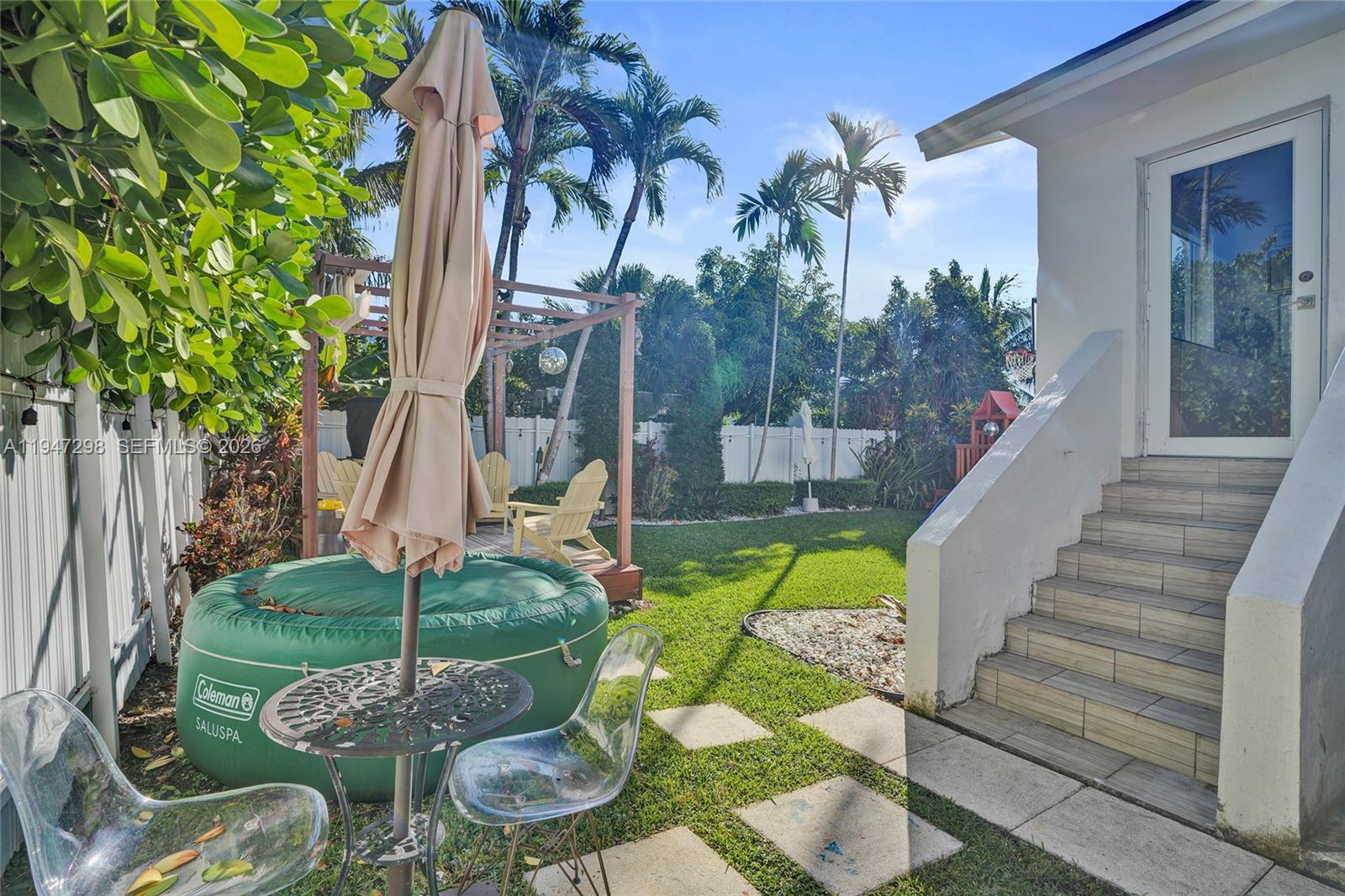 9181 Byron Avenue Surfside, FL 33154 - Photo 13 of 51 a backyard of a house with table and chairs