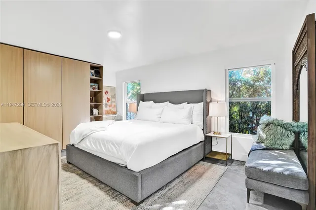 a bedroom with a bed window and a couch