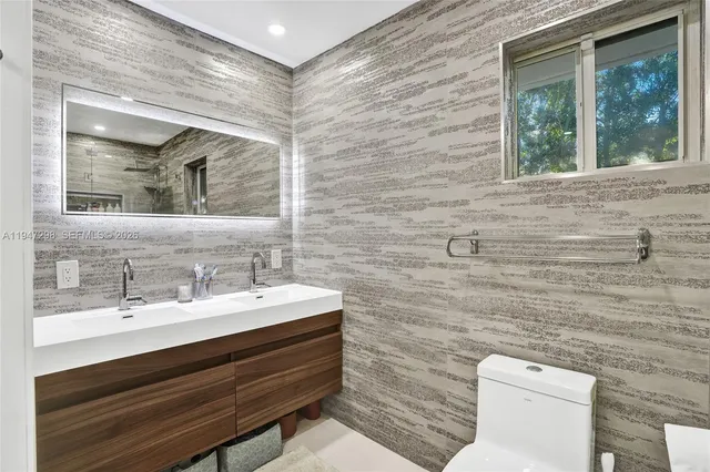 a bathroom with a toilet a sink and mirror