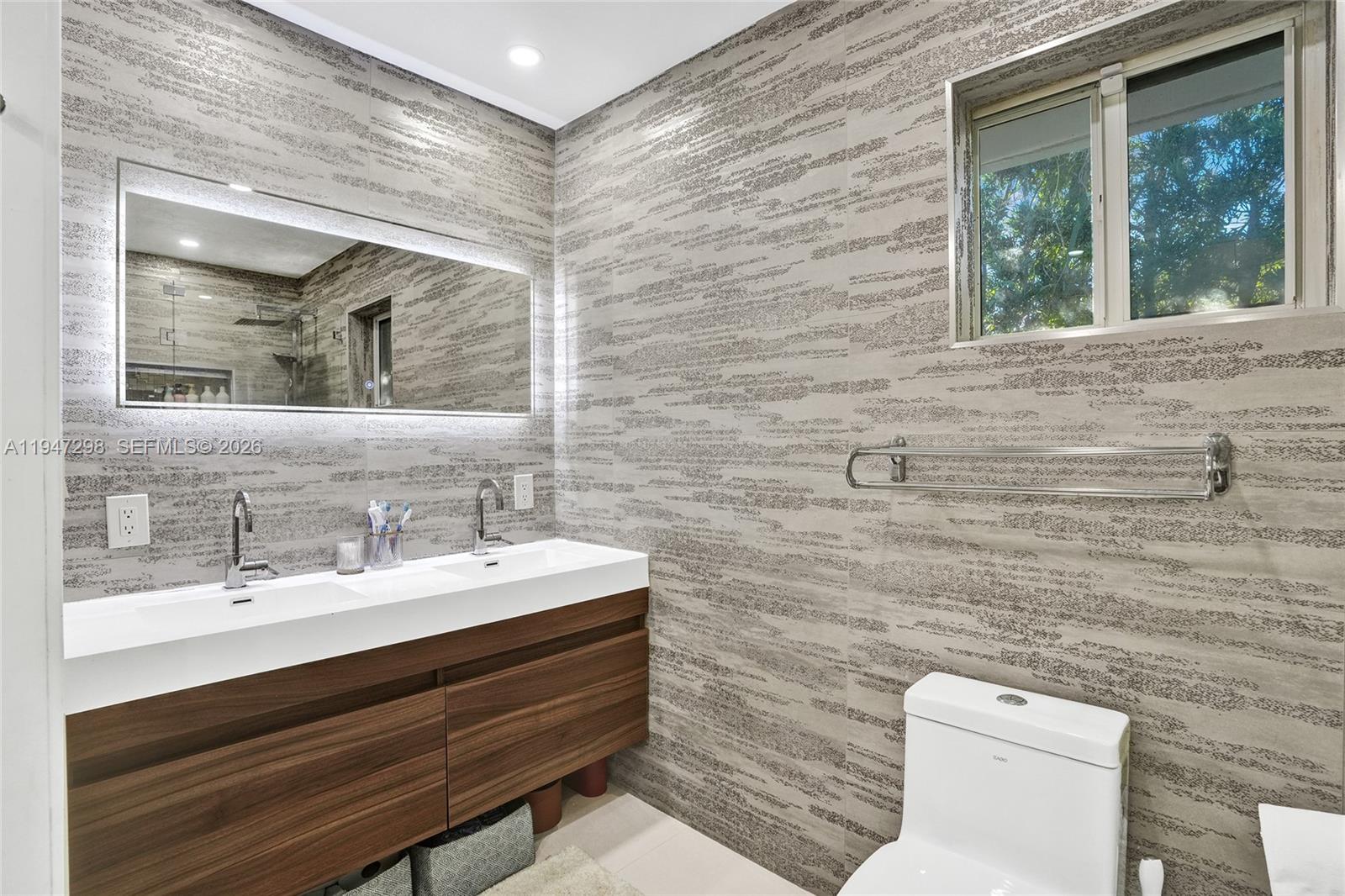 9181 Byron Avenue Surfside, FL 33154 - Photo 20 of 51 a bathroom with a toilet a sink and mirror