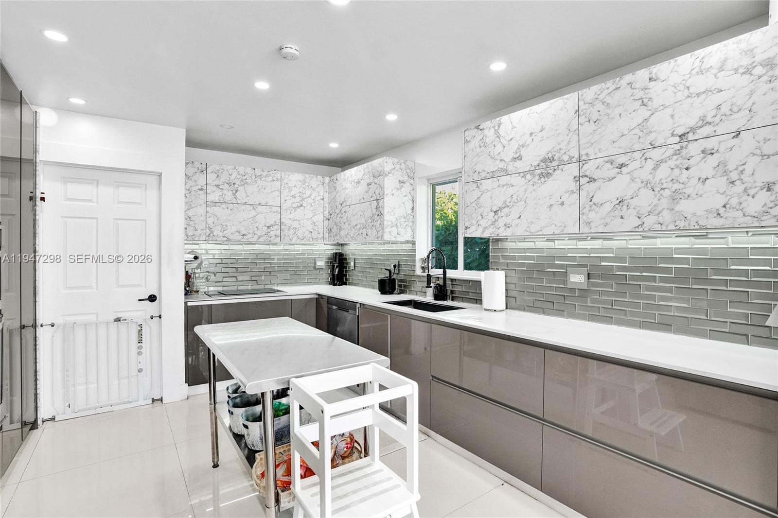 9181 Byron Avenue Surfside, FL 33154 - Photo 28 of 51 a kitchen with a sink a stove a refrigerator and cabinets