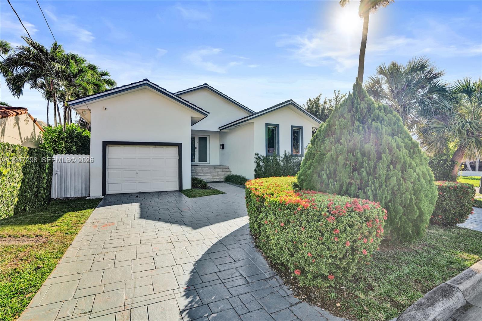 9181 Byron Avenue Surfside, FL 33154 - Photo 5 of 51 a front view of a house with garden