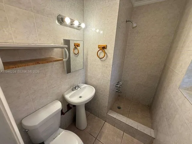 a bathroom with a toilet sink and shower