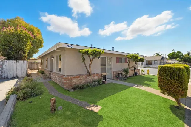a view of a backyard with table and chairs and potted plants and wooden fence