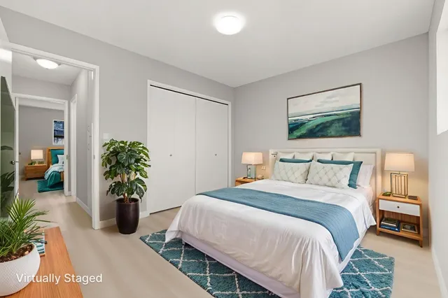 a bedroom with a bed table and a potted plant