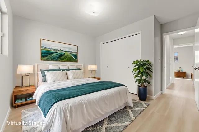 a bedroom with bed and a potted plant