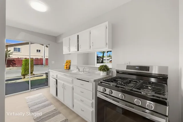 a kitchen with stainless steel appliances a stove and white cabinets