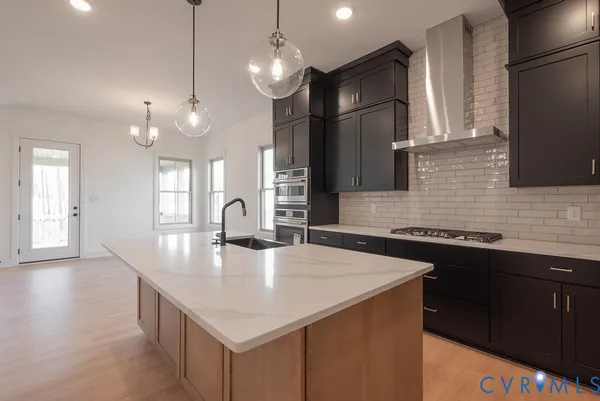 a view of a kitchen with a sink and dishwasher a fireplace with wooden floor