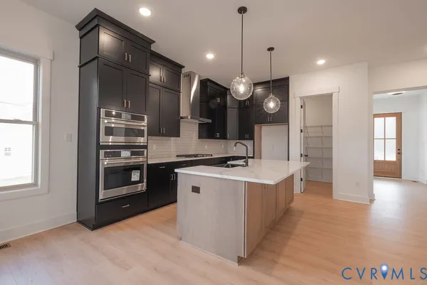 a kitchen with stainless steel appliances granite countertop a sink a stove and a refrigerator