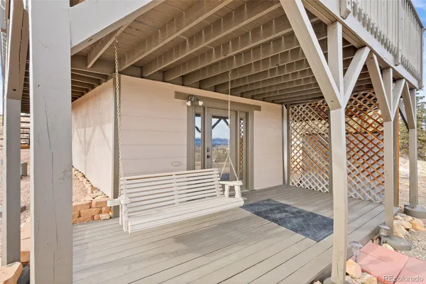 a view of a terrace with lawn chairs and wooden fence